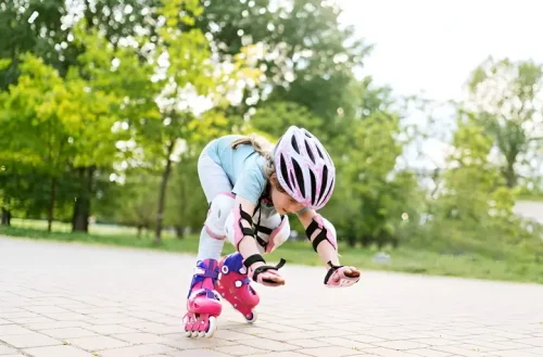 کودک اسکیت باز در حال زمین خوردن